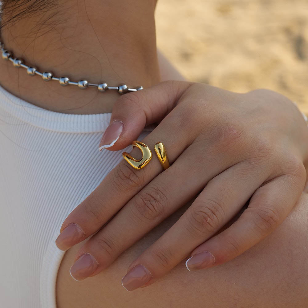 Close-up of a hand wearing gold ring JZ1254 with a blurred background