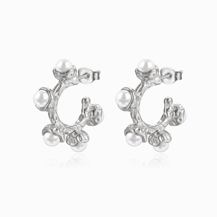 Silver earrings with pearl-like beads on a white background