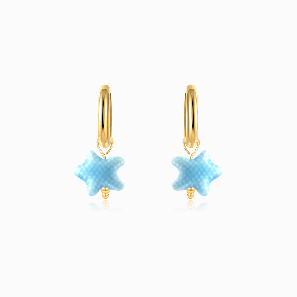 Gold hoop earrings with blue ceramic starfish on a white background