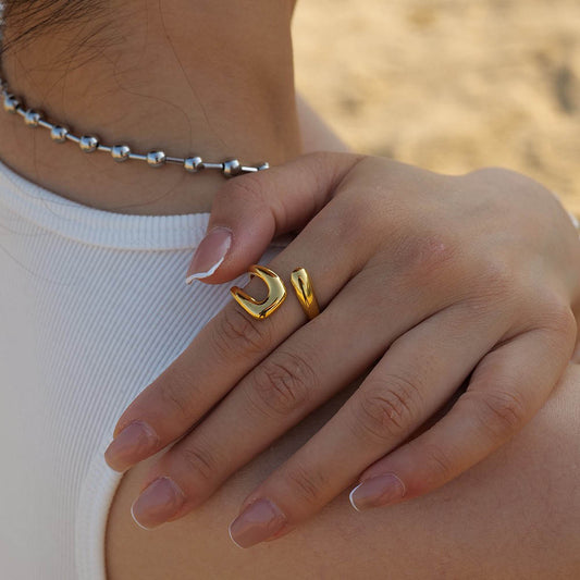 Close-up of a hand wearing gold ring JZ1254 with a blurred background