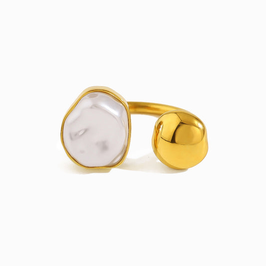 Gold ring with a white irregular pearl on a white background